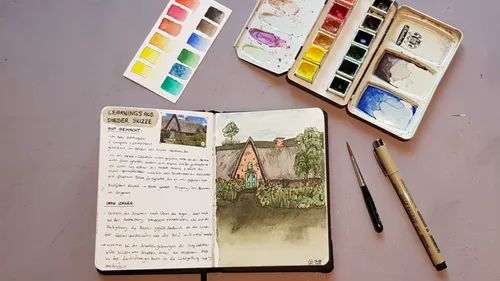 Sketchbook with countryside drawing and watercolors.
