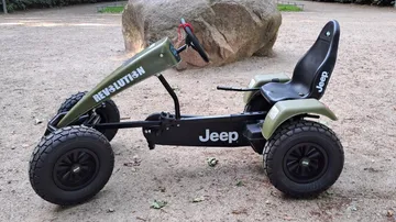 Offroad-Pedalkart parkt auf einem Sandweg.