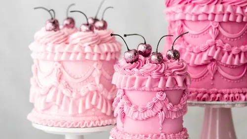 Pink decorative cakes with glitter cherries.