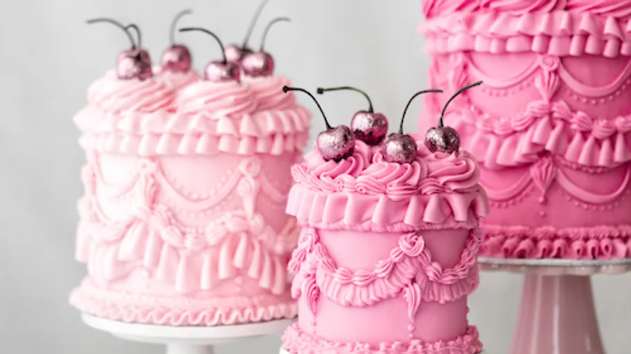 Pink decorative cakes with glitter cherries.