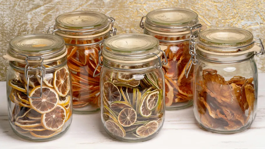 Jars filled with dried citrus slices on table.