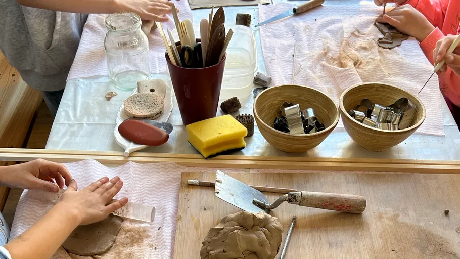 Children crafting with clay at a table.