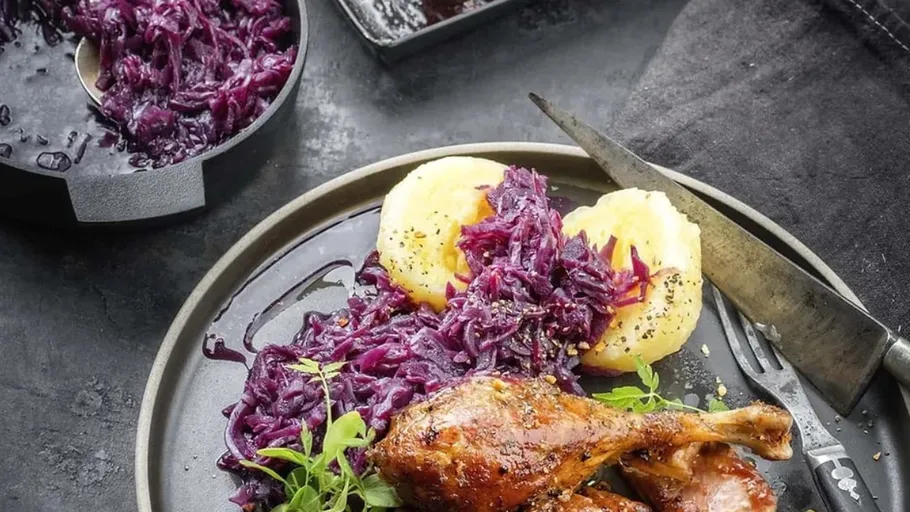 Gebratene Ente mit Rotkohl auf Teller.