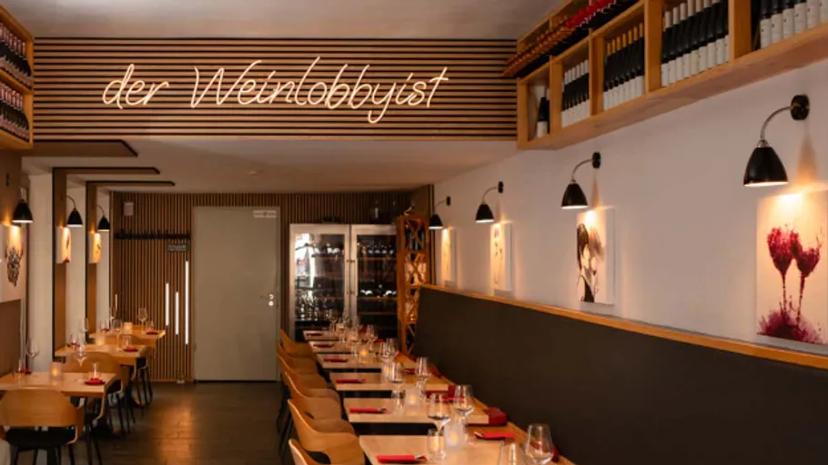 Restaurant-Innenraum mit Tischen und Weinlagerung.