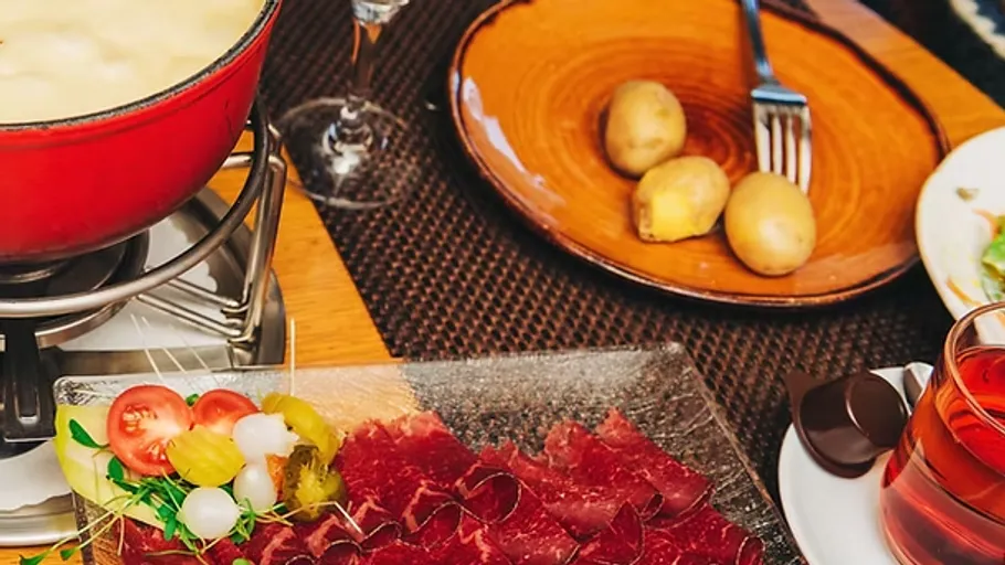 Käsefondue mit Beilagen auf dem Tisch.