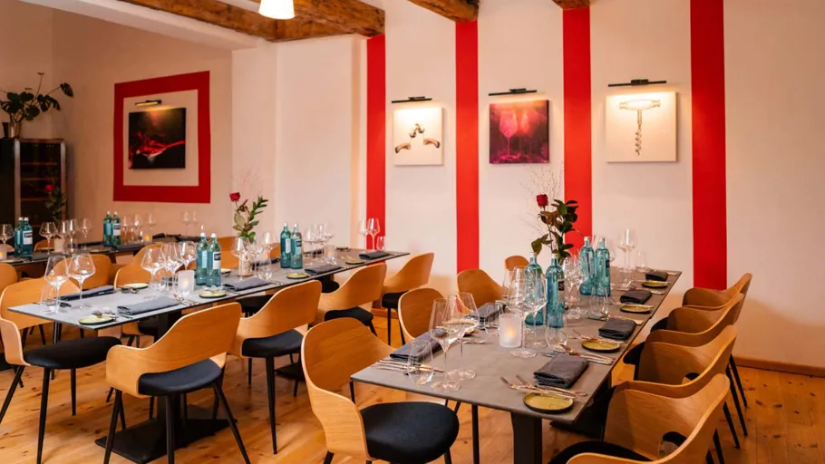 Elegantes Esszimmer mit gedeckten Tischen und Kunstwerken.