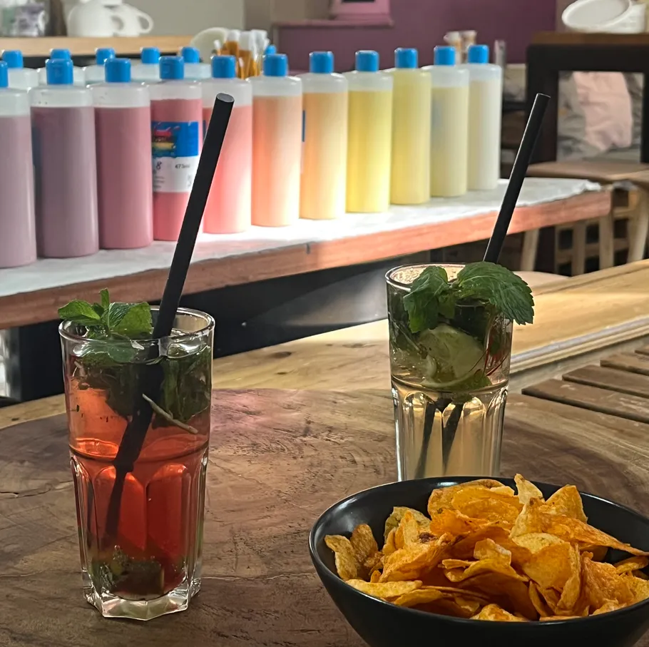 Two cocktails with chips on table.