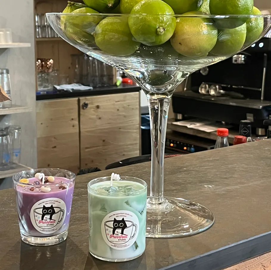 Limes in glass bowl on counter, candles nearby.