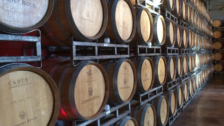 Wooden barrels stacked in a wine cellar.