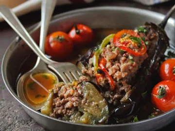 Stuffed eggplant served with minced meat and red tomatoes.