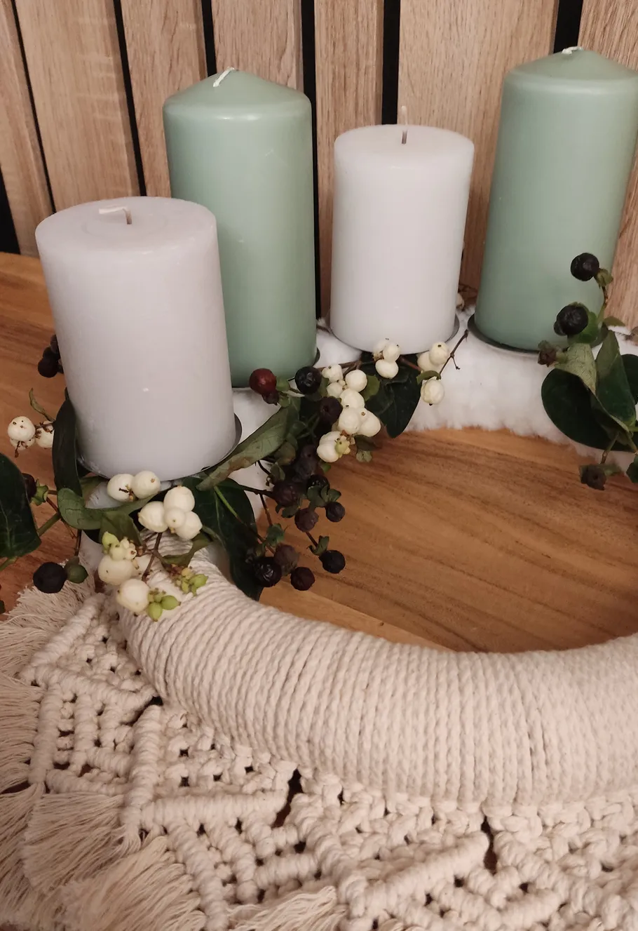 Kerzen und Beeren auf einem Holztisch.