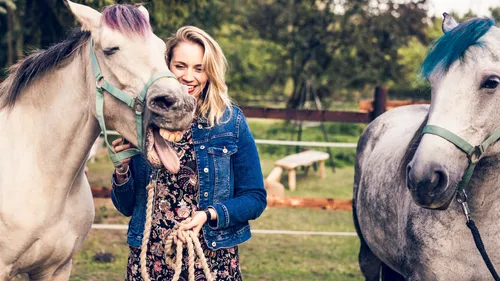 Woman with two horses in a field.