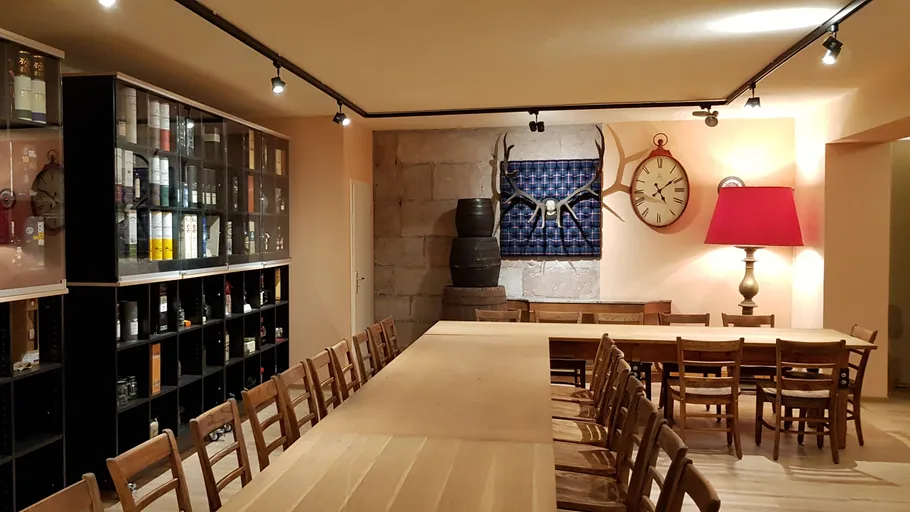 Room with wooden tables and wine shelves.