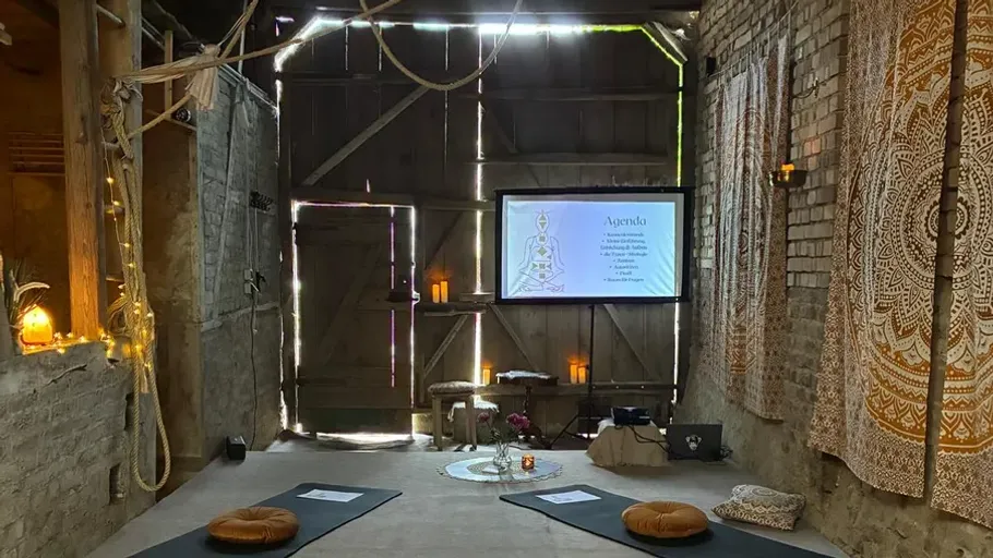 Yoga studio with cushions and projected agenda.