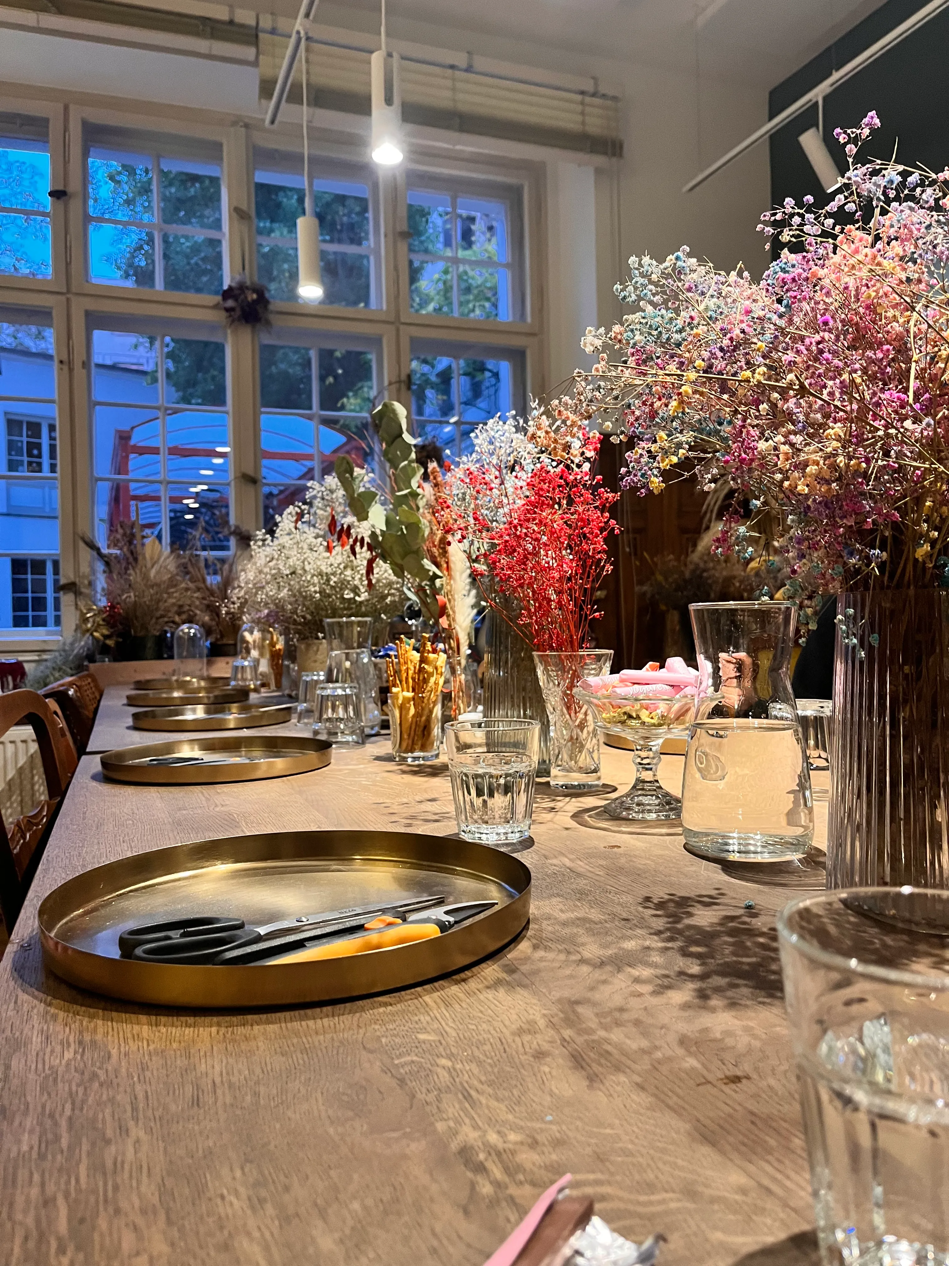 Table with flowers and tools in a room.