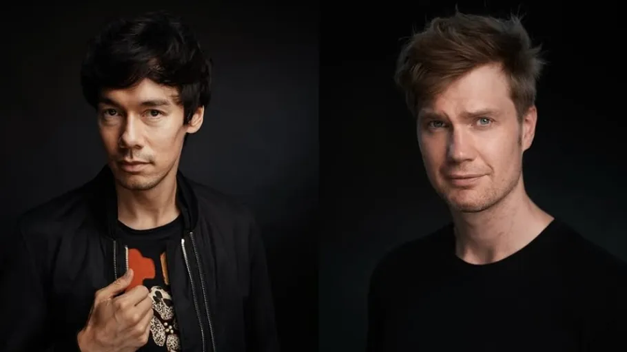 Two men posing against dark background.