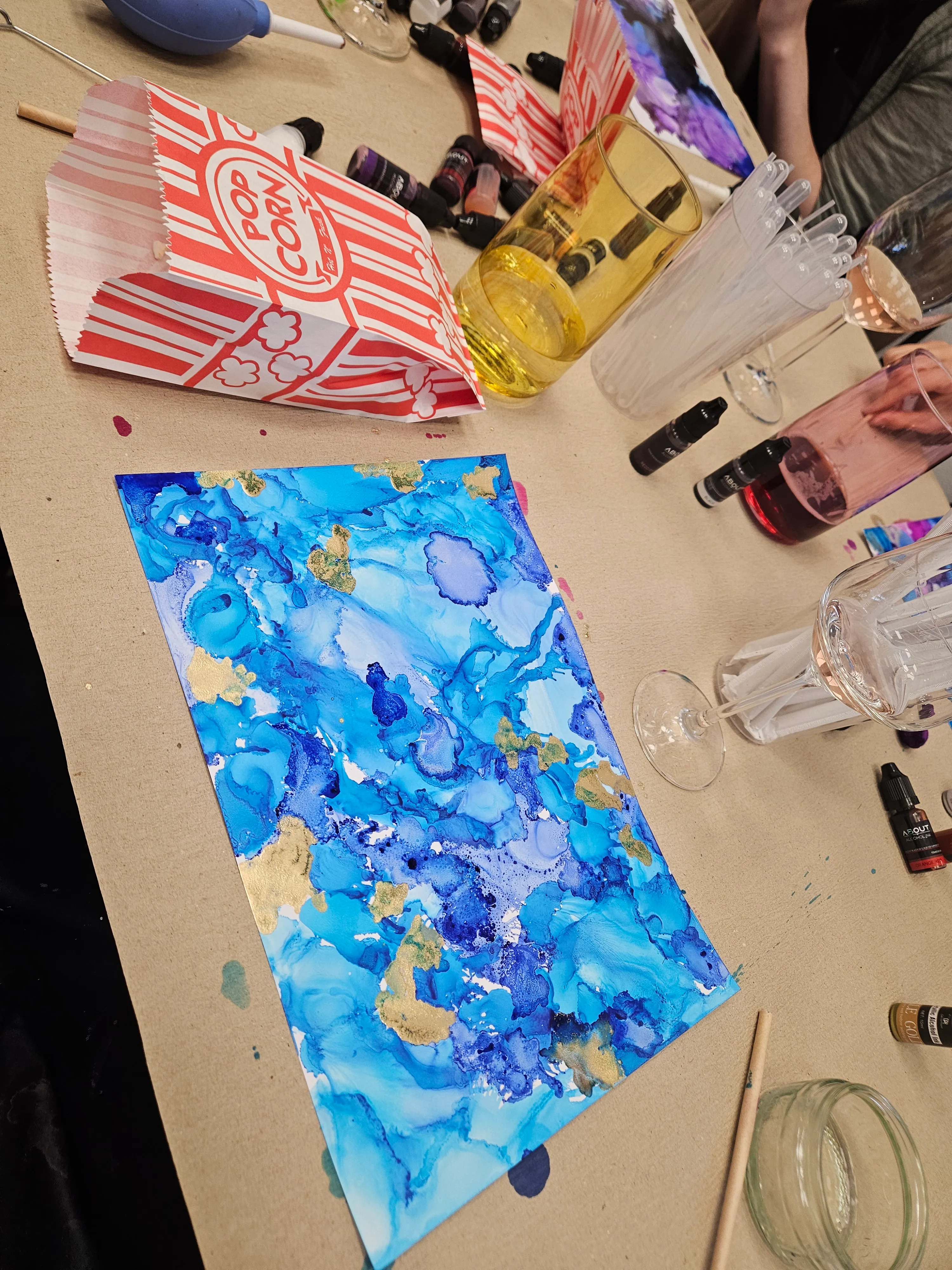 Blue abstract painting on a messy table.