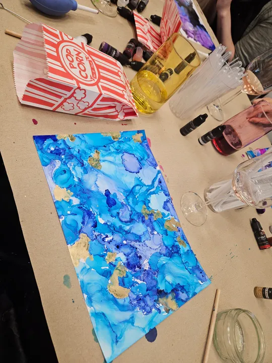 Blue abstract painting on a messy table.