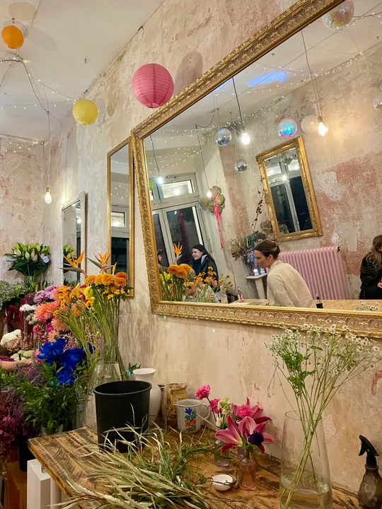 Blumen auf rustikalem Tisch mit Spiegeln.