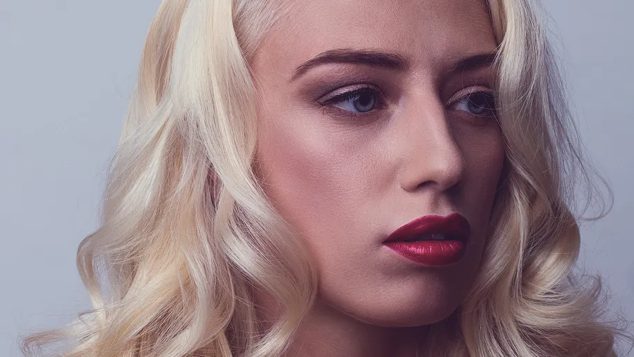 Woman with blonde hair, looking sideways.