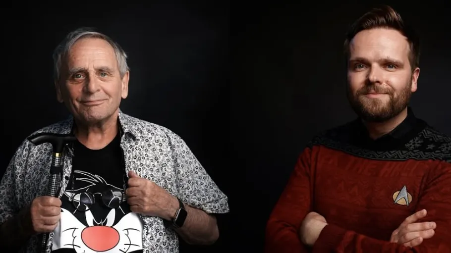 Two men smiling against dark background.