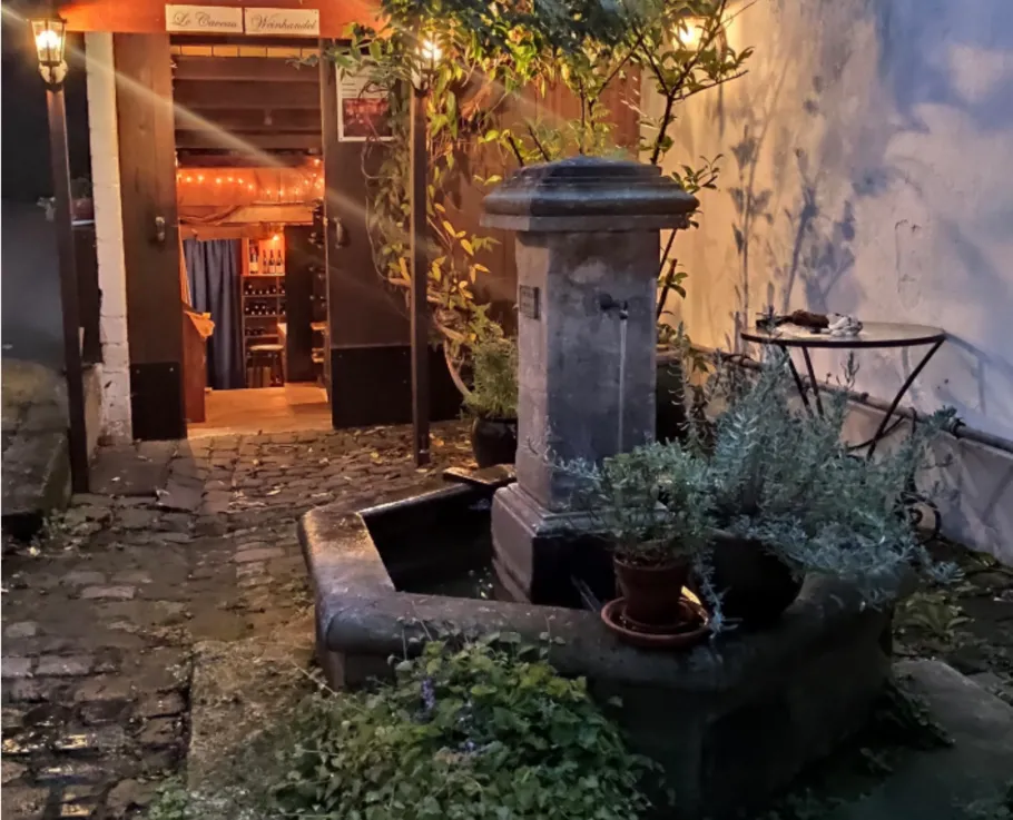 Stone fountain in a dimly lit courtyard.