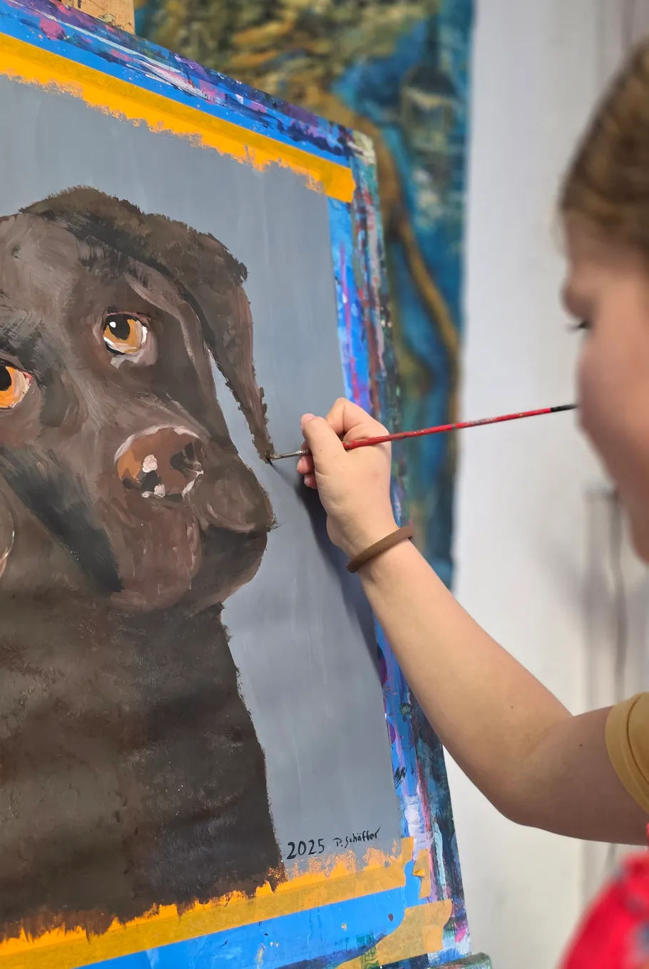 Artist painting a dog portrait on canvas.