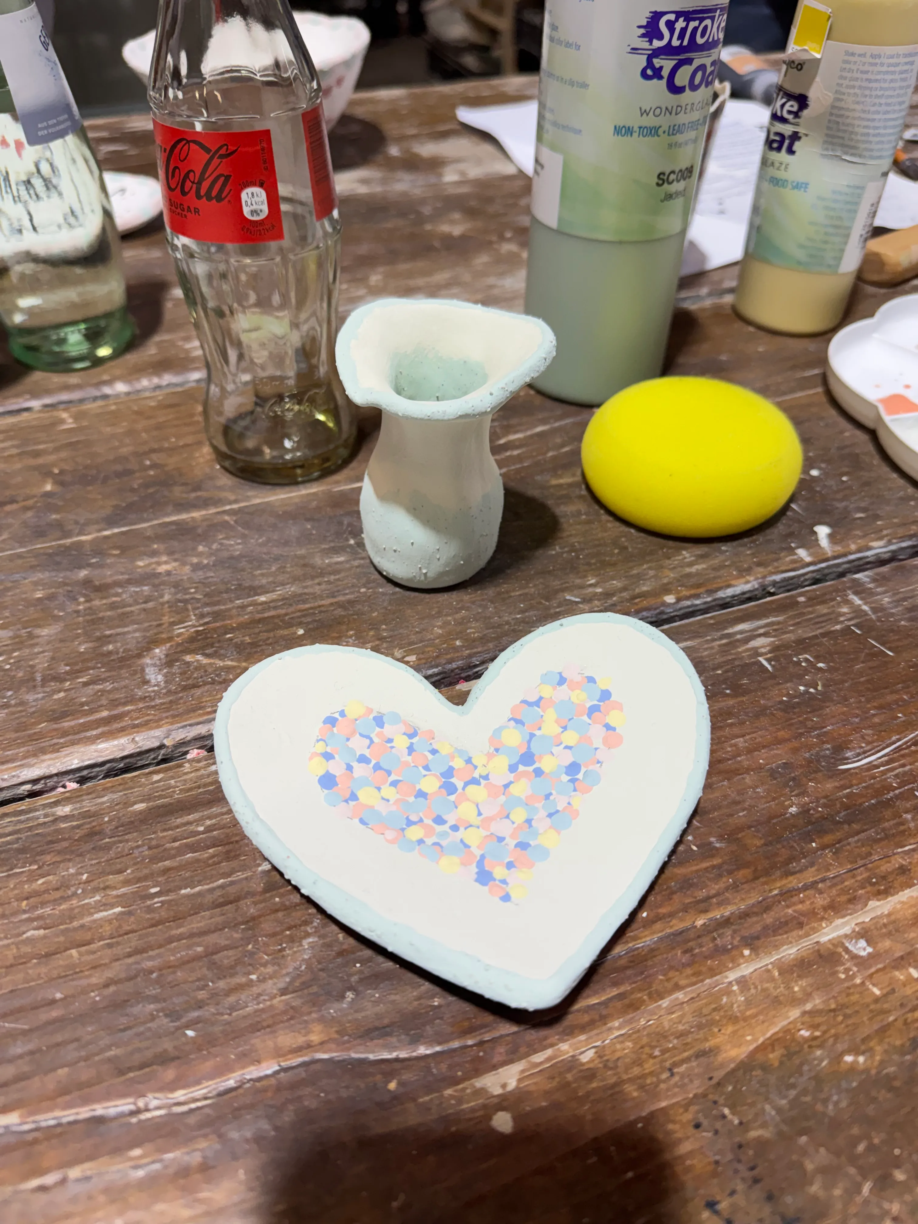 Dekorierte Keramik und Flaschen auf Holztisch.