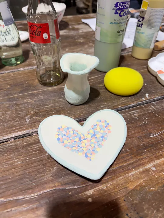 Decorated ceramics and bottles on wooden table.