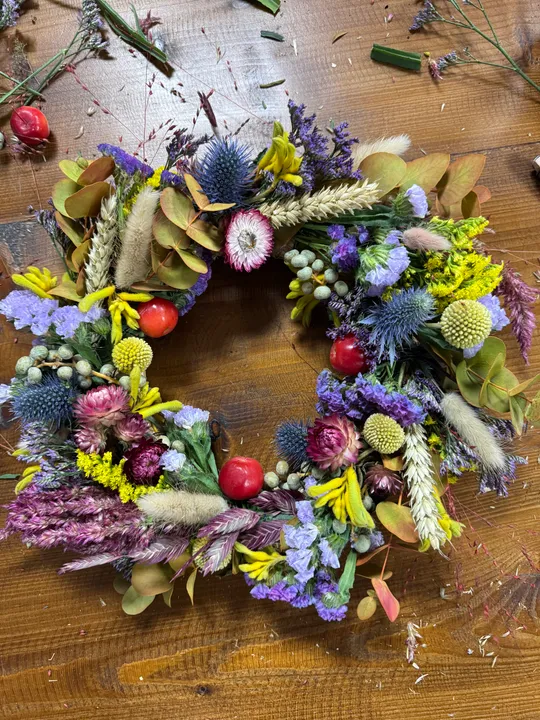 Bunter Blumenkranz auf Holztisch.