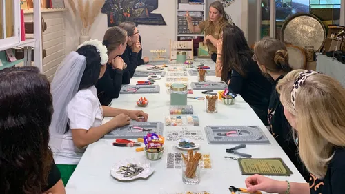Women at a craft workshop table, instructor speaking.
