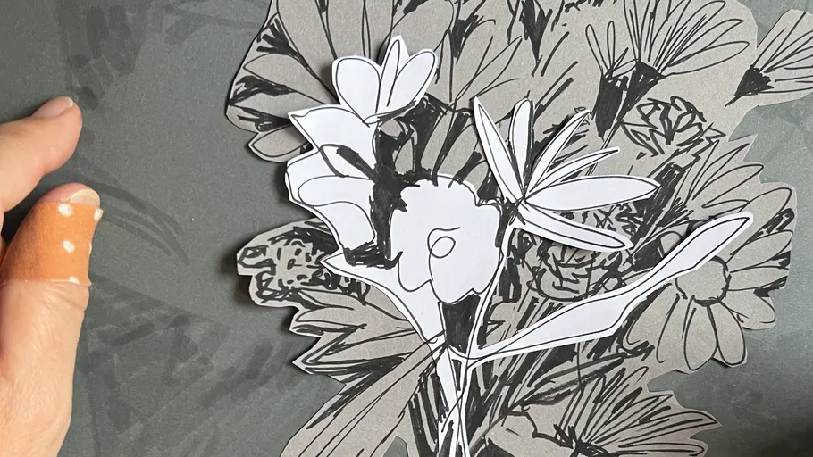 Hand hält floralen Papierschnittentwurf.