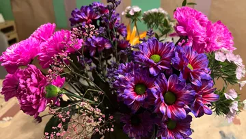 Bunter Blumenstrauß auf Holztisch.