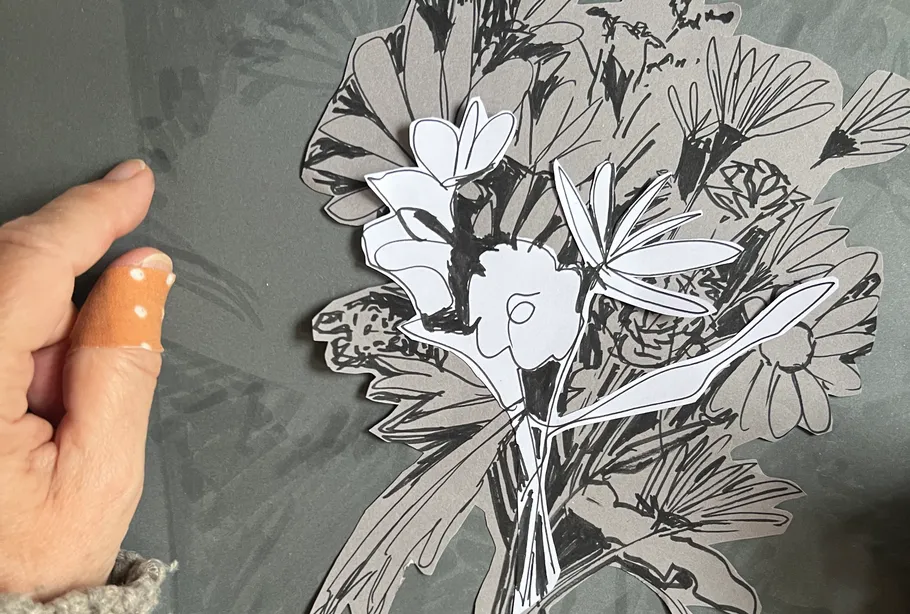 Hand hält gestapelte Papierblumen.