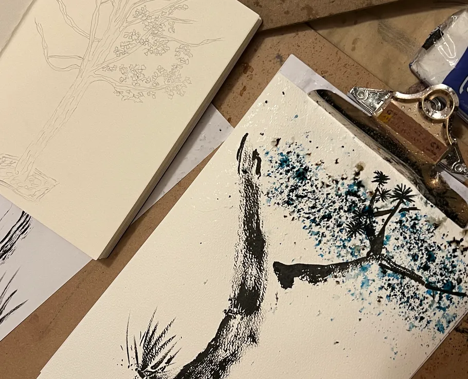 Sketchbook with tree sketches on table.