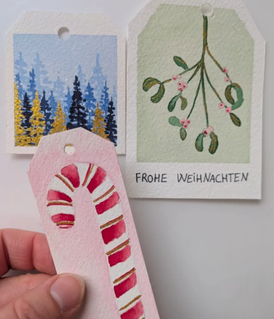 Hand hält weihnachtliche Geschenkanhänger.