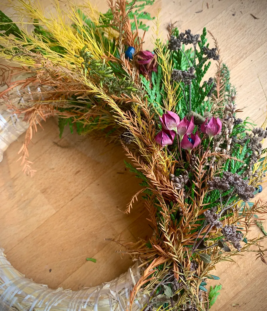 Floral wreath with dried flowers on table.
