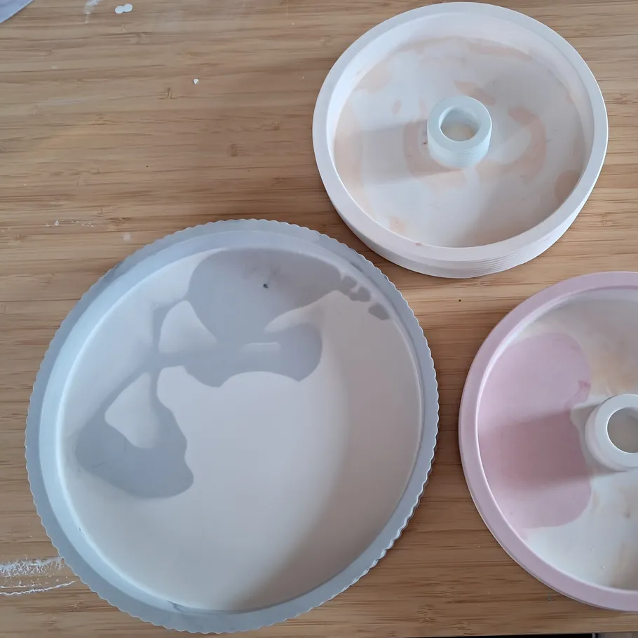 Three round silicone molds on wooden surface.