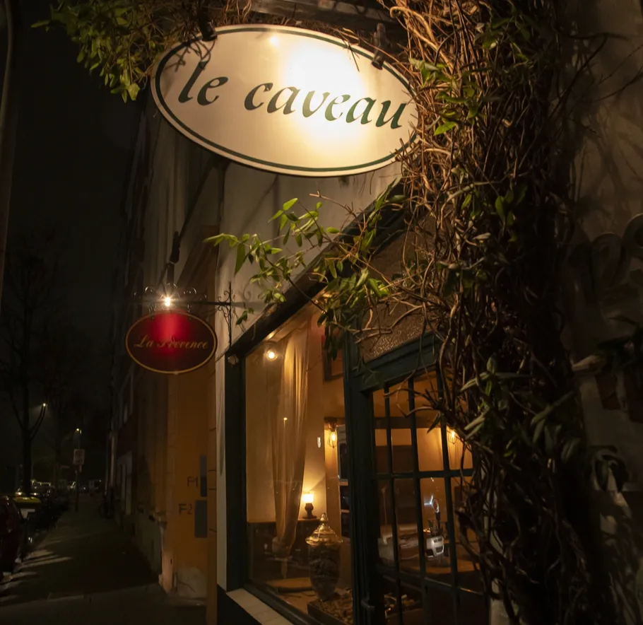 Restaurant exterior with illuminated sign at night.