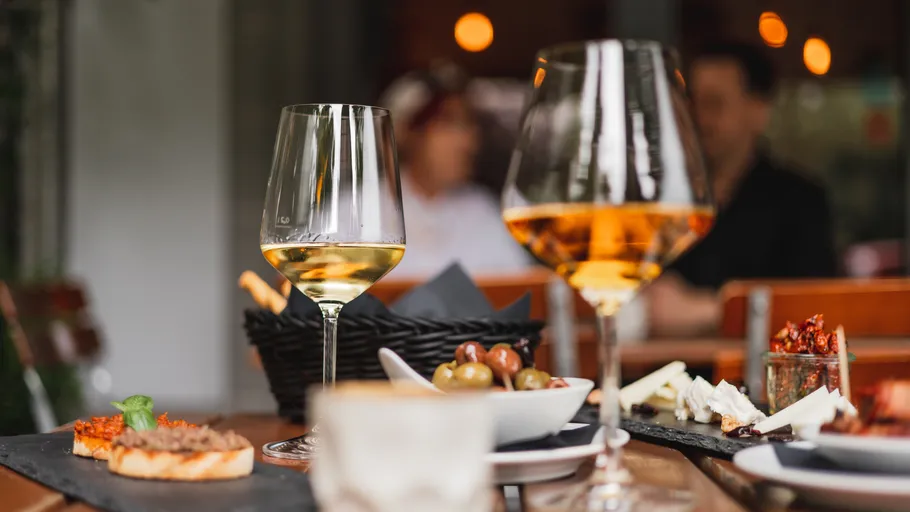 Wine glasses and appetizers on wooden table.