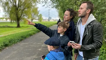 Family pointing and looking on a park path.