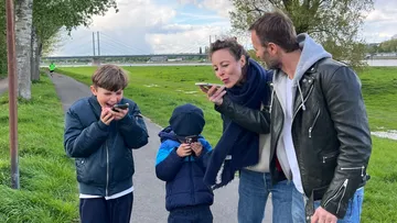 Family enjoying ice cream in a park.