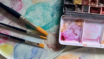 Pinsel und Aquarellfarben auf Palette.