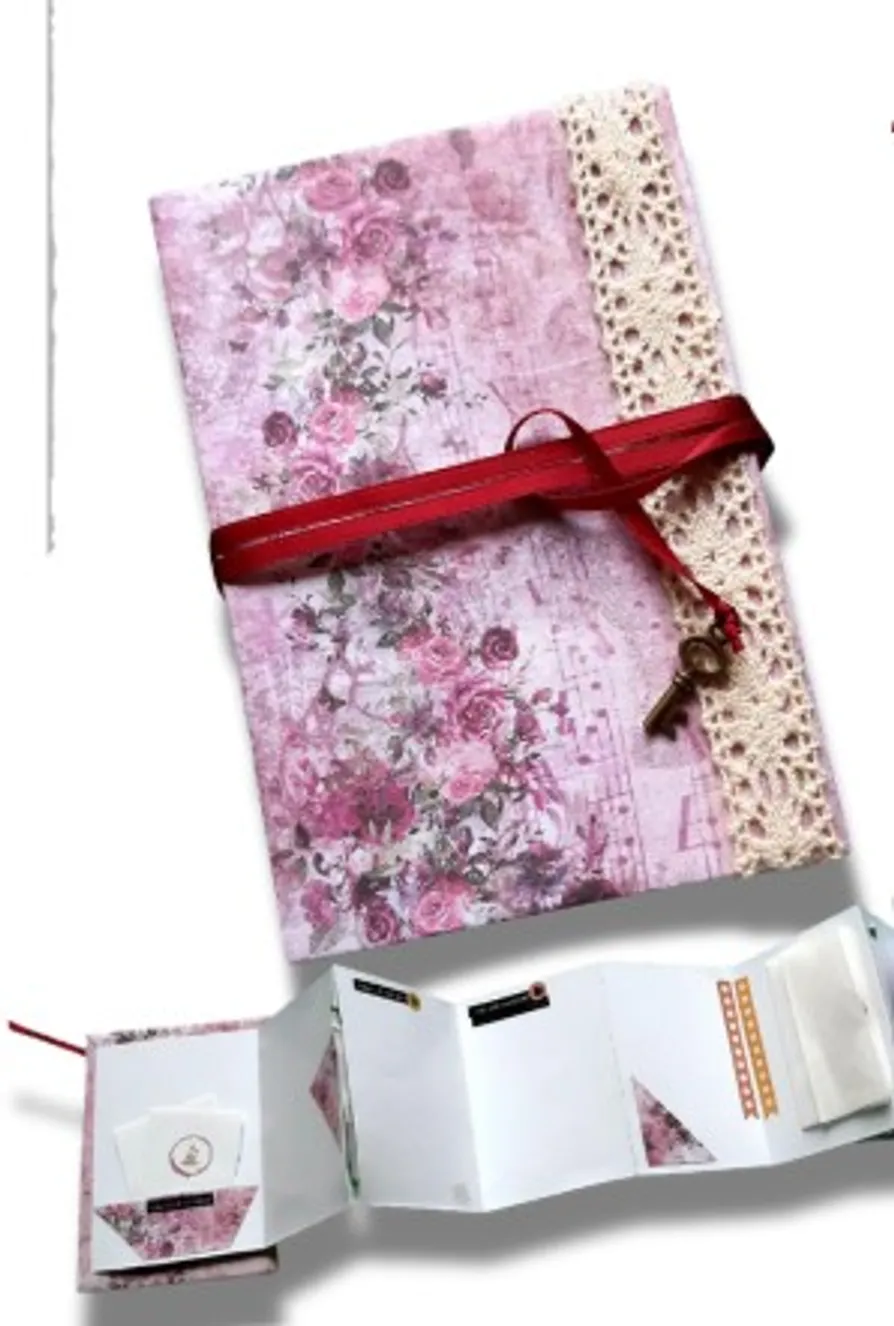 Floral pink scrapbook with red ribbon and key.