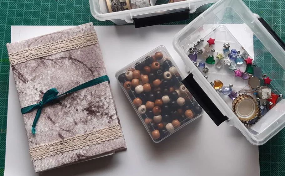 Bastelmaterialien in Boxen auf Tisch organisiert.