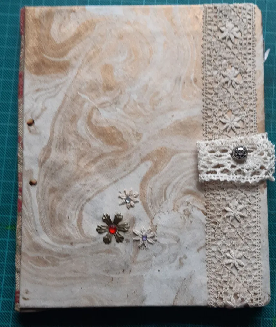 Decorative journal with lace and floral design.
