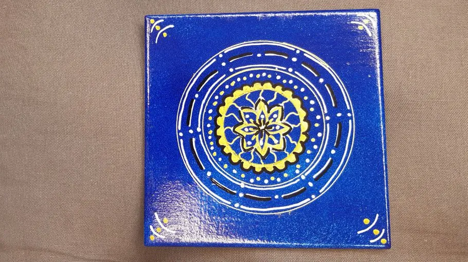 Blue ceramic tile with yellow floral design.