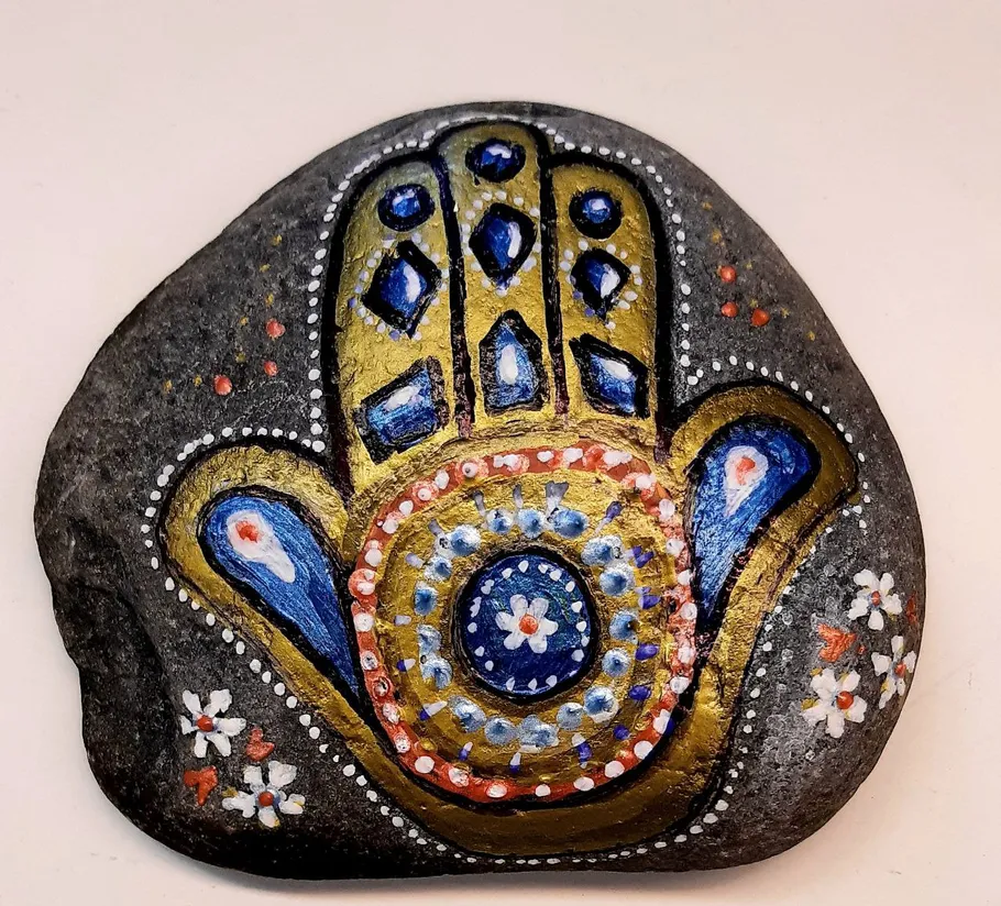 Painted Hamsa stone with colorful decorations.