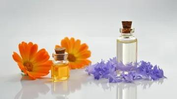 Bottles of oil with orange flowers.