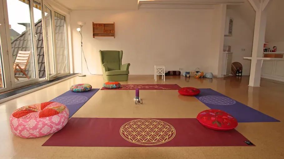 Meditation space with cushions and mats in room.